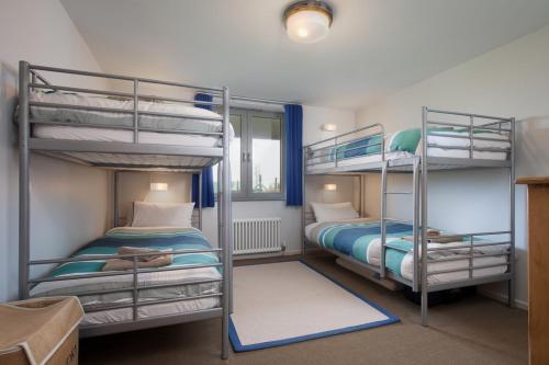 a room with two bunk beds and a room with at Sloopside Main House in the heart of Bantham with sea views in Bantham