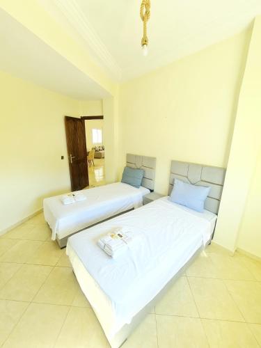 two beds in a room with white walls at Appart Hotel Fes - Joud Families & Travelers in Fès