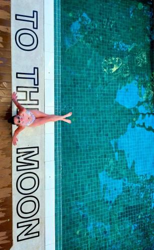 a woman is swimming in a swimming pool at To The Moon Guesthouse in Chiang Mai