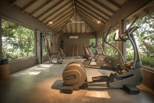 a gym with treadmills and ellipticals in a room with windows at Laluna Boutique Hotel & Villas in Saint Georgeʼs