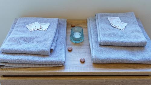 dos toallas están sentadas en una mesa de madera con medicinas en Le Belvédère - WIFI Fibre - Parking gratuit, en Gap