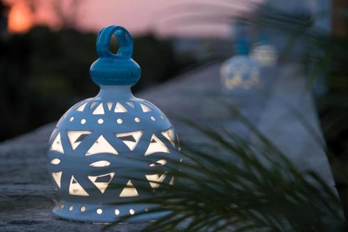 a blue glass bottle with lights on top of a plant at B&B Il Palazzotto di Luca Luxury Suites in Lecce