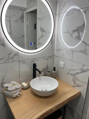 une salle de bain avec un lavabo blanc et un miroir dans l'établissement appartement vue mer agay, à Agay