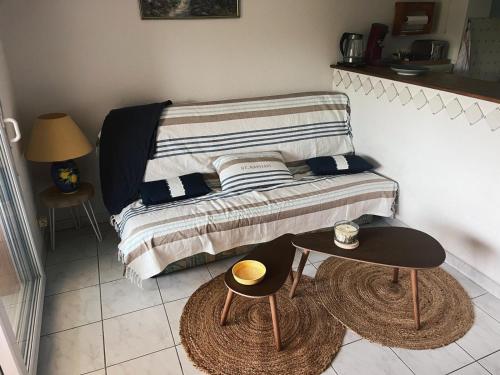 - une petite chambre avec un lit et 2 tables dans l'établissement appartement vue mer agay, à Agay