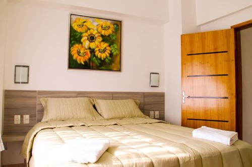 a bedroom with a bed with a painting on the wall at Müller Hotel in Bella Vista