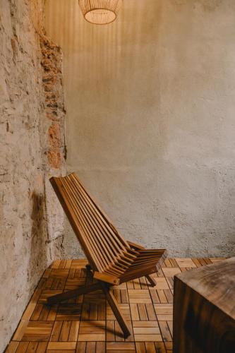 a wooden chair sitting on a floor next to a table at Hotel Boutique Casa Yága in Querétaro