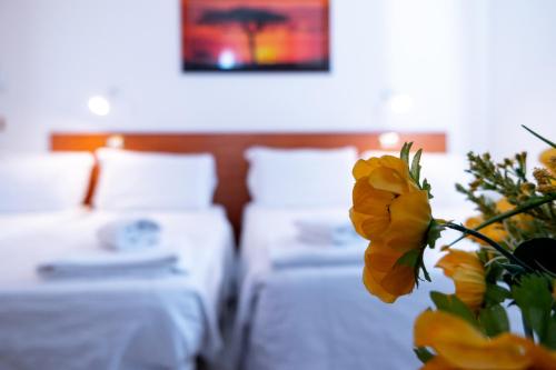 a hotel room with two beds and a yellow flower at Hotel New Aurora Venice in Marghera