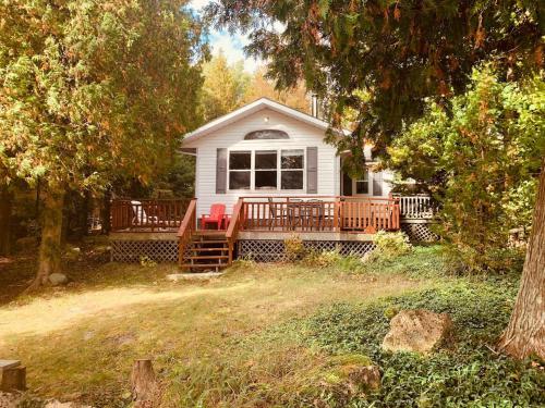a white house with a porch with red chairs at Stella by Starlight in Tobermory