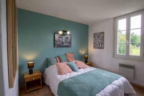 a bedroom with a bed with a blue wall at Valmy in Brantôme