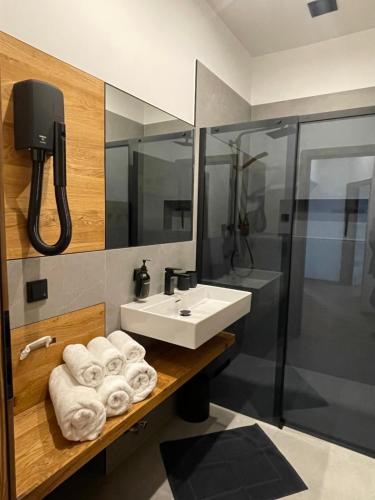 a bathroom with a sink and a shower with towels at d'Herberg in Bad Hofgastein