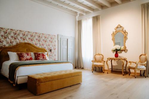 a bedroom with a bed and a mirror and chairs at Wine Relais Villa Cipolla Pieropan in Tregnago