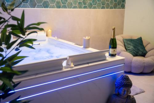 - un bain à remous avec une bouteille de vin et une statue dans l'établissement MaLoveRoom, à Bevons