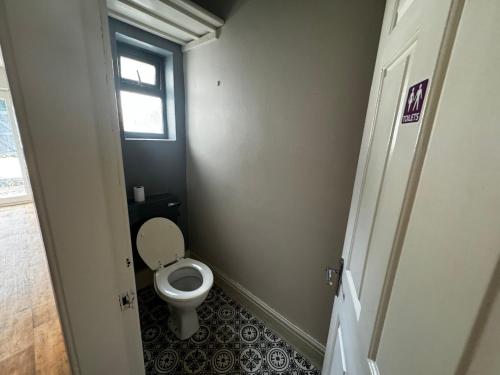 a small bathroom with a toilet and a window at Double-Bed Manchester Close To Bolton City Centre C4 in Little Hulton