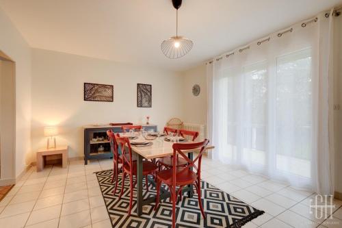 une salle à manger avec une table et des chaises rouges dans l'établissement La Marnière, Maison avec jardin , 6 V, Parking, à Chambray-lès-Tours
