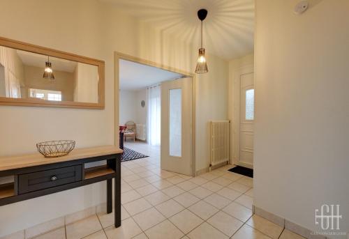 a living room with a table and a mirror at La Marnière, Maison avec jardin , 6 V, Parking in Chambray-lès-Tours