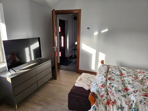 a bedroom with a bed and a dresser and a television at Suaimhneas in Lahinch
