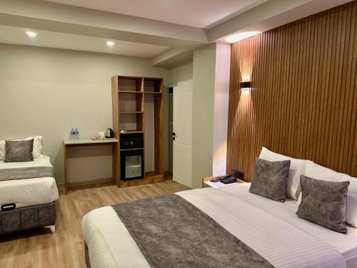 a hotel room with two beds and a desk at Skymoon Istanbul Airport Hotel in Arnavutköy