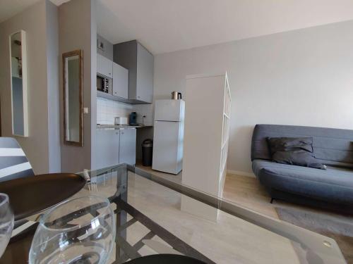 un salon avec un canapé et une table en verre dans l'établissement Appt Studio LA ROCHELLE - LR110-F56, à La Rochelle