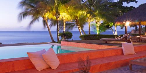 a resort with a swimming pool and the ocean at Laluna Boutique Hotel & Villas in Saint Georgeʼs