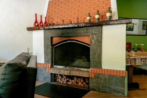 a living room with a fireplace with vases on top at Hotel Geneve - 2km do Capivari in Campos do Jordão