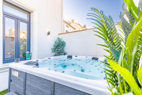 una vasca idromassaggio in un cortile con piante di Bliss Triplex - Hyper Centre - Sauna - BBQ - Jacuzzi - LRACANNES a Cannes