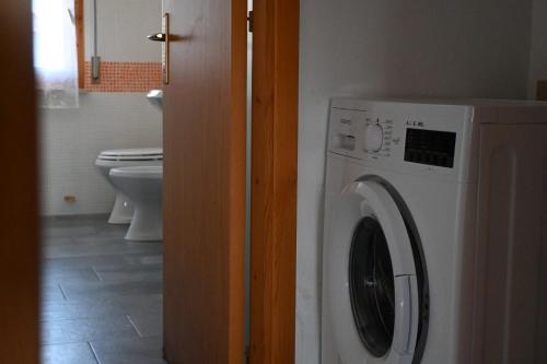 a washing machine in a bathroom with a toilet at S076 - Sirolo, bilocale in centro, con terrazzo e aria condizionata! in Sirolo