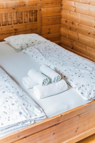 a bed with two pillows and towels on it at Dachstein Chalet - Mountain view in Bad Goisern