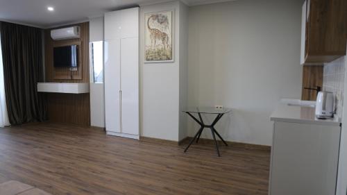 a kitchen with white walls and a wooden floor at Golden Sun Kobuleti in K'obulet'i