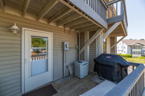 a porch of a house with a door and a trash can at Harbours 10- Condo with community pool in South Haven