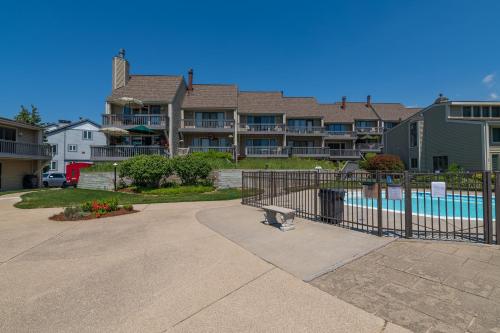 a apartment complex with a swimming pool and a building at Harbours 10- Condo with community pool in South Haven