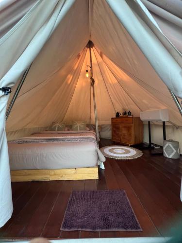 a bedroom with a bed in a tent at KA MANIcamp in Angsri