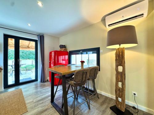 a dining room with a table and chairs and a lamp at Le Pigeonnier d'antan à Beaucaire,Fourques in Beaucaire