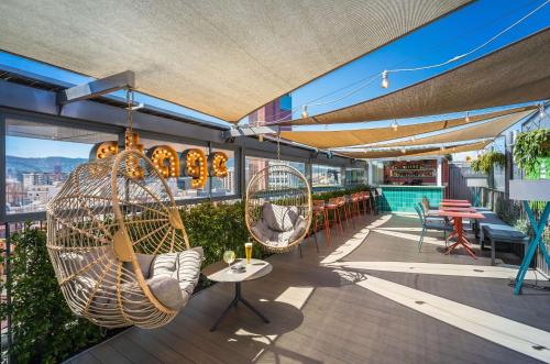 a patio with two hanging chairs and a table at Occidental Barcelona 1929 in Barcelona