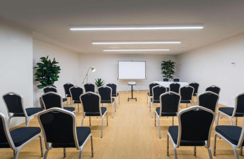 a conference room with chairs and a whiteboard at Occidental Barcelona 1929 in Barcelona