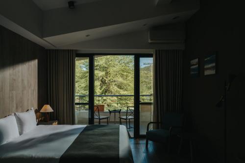 a bedroom with a bed and a large window at Yanyu Yuchi BY REINDEER in Yuchi