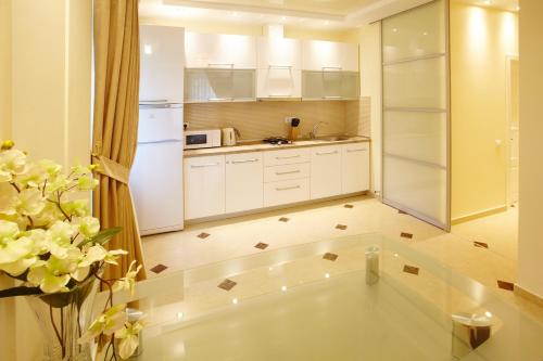 a kitchen with white cabinets and a white refrigerator at Ultra Central Park Apartments in Chişinău