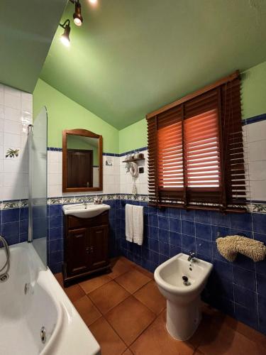 a bathroom with a tub and a toilet and a sink at Hotel Baviera in Linares