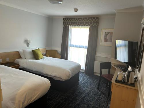 a hotel room with two beds and a window at Best Western Appleby Park Hotel in Tamworth