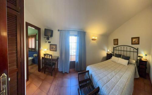 a bedroom with a bed and a table and a window at Hotel Baviera in Linares