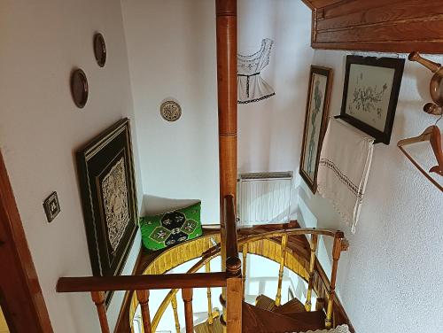 a spiral staircase in a home with a wooden railing at Woodman’s home in Vlatanéoi