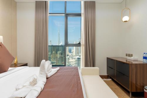 a bedroom with a bed and a large window at Samaya Holiday Homes - Family Luxury Suites in Dubai