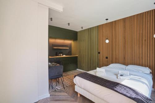 une chambre avec un grand lit blanc et une cuisine dans l'établissement Studio in Neuilly Porte Maillot by Studio prestige, à Neuilly-sur-Seine