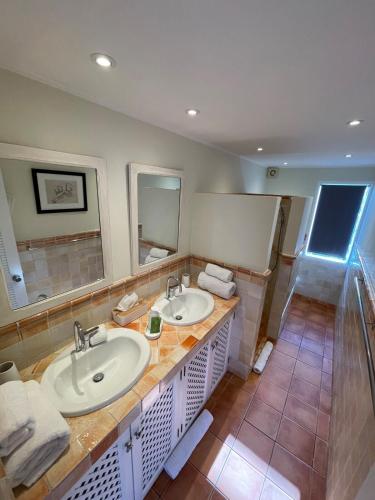 a bathroom with two sinks and a large mirror at Villa Boa in Marigot