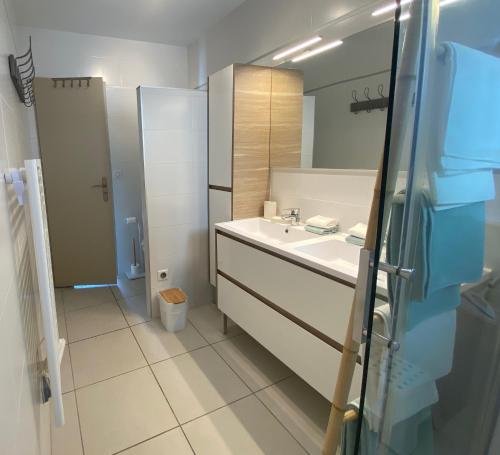 ein Badezimmer mit Waschbecken und Spiegel in der Unterkunft Maison 3 chambres, Parking, jardin, climatisation in Arles