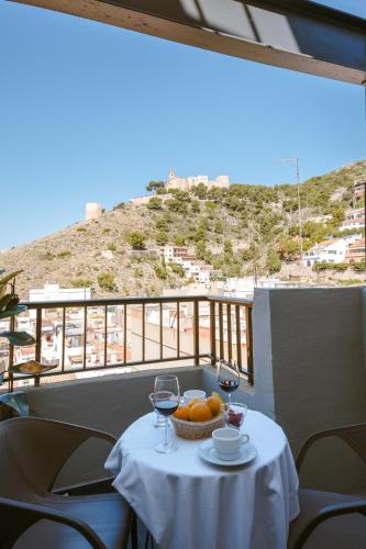 a table with a bowl of fruit and two glasses of wine at Moon Dreams Cullera in Cullera