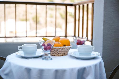 a table with a basket of fruit and two cups at Moon Dreams Cullera in Cullera