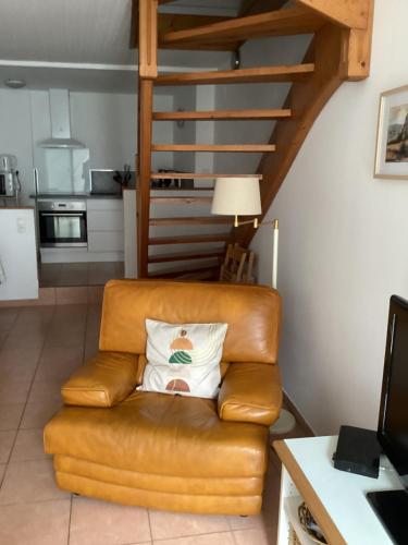 - un canapé en cuir brun avec un oreiller dans le salon dans l'établissement La maïsou, à Caussou