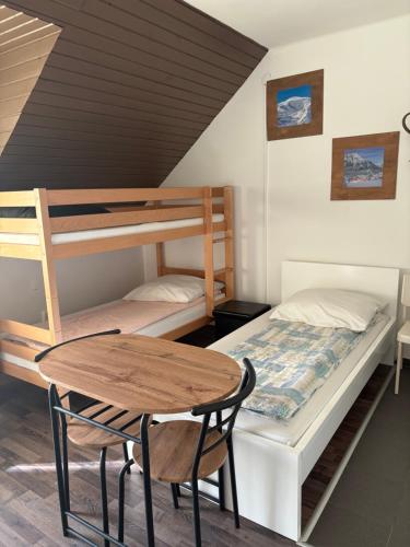 a bedroom with a bunk bed and a table at Sárga Csikó vendégház in Debrecen