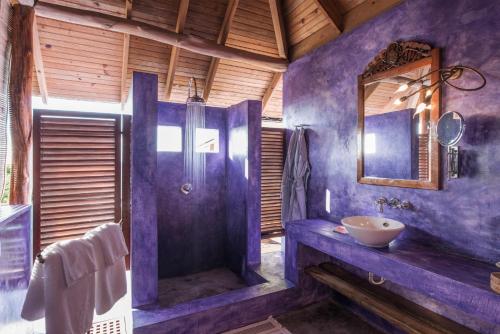 a purple bathroom with a shower and a sink at Laluna Boutique Hotel & Villas in Saint Georgeʼs