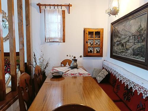 a dining room with a wooden table and chairs at Woodman’s home in Vlatanéoi